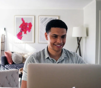 Smiling young finance professional reviewing a report at his desk — representing the wide range of global career opportunities available after qualifying as ACCA.