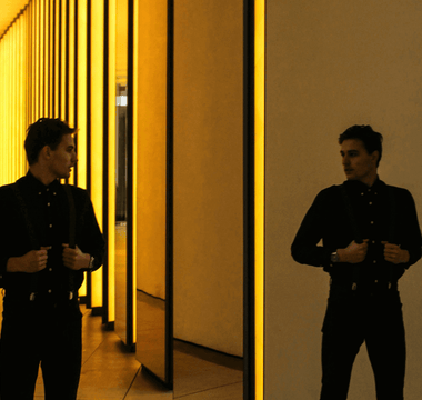 Man standing between mirrored golden walls, representing the challenge of balancing two full-time jobs and identity conflict.
