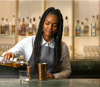 A bartender serving a drink, reflecting how customer-facing hospitality experience can build the soft skills future accountants need.
