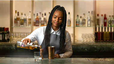 A bartender serving a drink, reflecting how customer-facing hospitality experience can build the soft skills future accountants need.