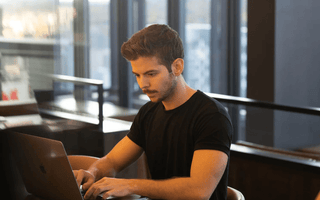 Focused student studying on a laptop in a modern workspace — representing the decision process of choosing the right ACCA professional paper to match strengths and goals.