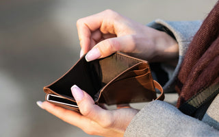 Close-up of a person holding an empty wallet, illustrating cash flow problems and lack of available money.