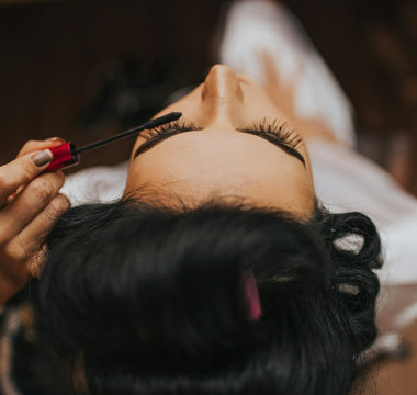 Close-up of a woman having mascara applied during a beauty treatment, representing the global cosmetics and fragrance industry discussed in the article.