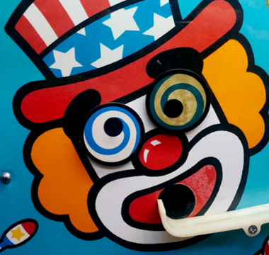 Colourful carnival clown face with spiral eyes and a patriotic hat, symbolising irony and misplaced judgment in a story about AI misuse in professional training.