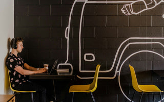 Young entrepreneur working on a laptop in a modern workspace, illustrating how technology and digital tools enable individuals to build and run successful businesses independently.