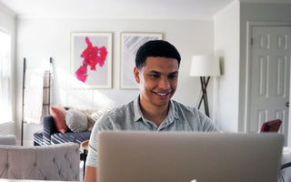 Smiling young finance professional reviewing a report at his desk — representing the wide range of global career opportunities available after qualifying as ACCA.