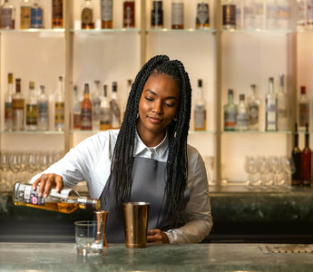 A bartender serving a drink, reflecting how customer-facing hospitality experience can build the soft skills future accountants need.