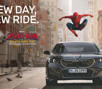 Spider-Man leaps above a black BMW driving through New York in a promotional image for Spider-Man: Brand New Day.
