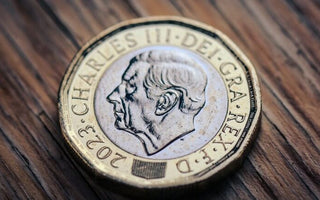 Close-up of a UK pound coin featuring King Charles III, symbolising money, earnings and financial rewards.
