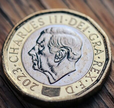 Close-up of a UK pound coin featuring King Charles III, symbolising money, earnings and financial rewards.