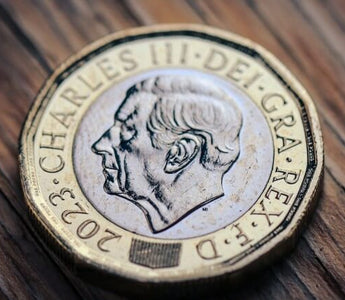 Close-up of a UK pound coin featuring King Charles III, symbolising money, earnings and financial rewards.