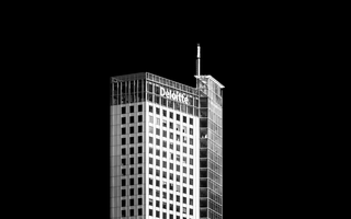 Deloitte office tower against a black background, symbolising corporate success and executive pay at Deloitte UK.