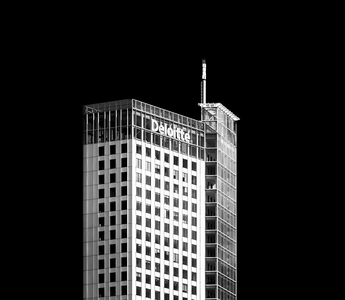 Deloitte office tower against a black background, symbolising corporate success and executive pay at Deloitte UK.