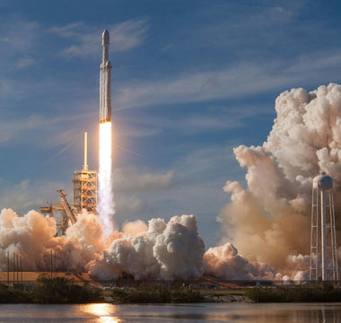 SpaceX rocket launching into the sky with bright flames and thick clouds of smoke surrounding the launch pad, symbolising innovation, ambition and the company’s planned IPO.