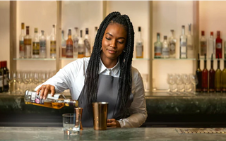 A bartender serving a drink, reflecting how customer-facing hospitality experience can build the soft skills future accountants need.