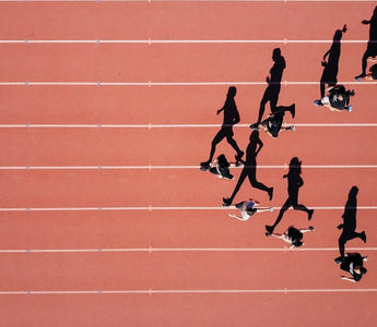 Sprinters racing in a 100m track event, representing how businesses compare their performance against industry benchmarks.