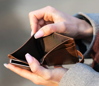 Close-up of a person holding an empty wallet, illustrating cash flow problems and lack of available money.