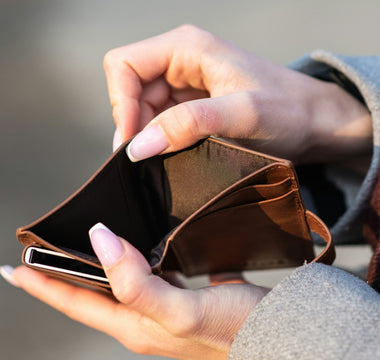 Close-up of a person holding an empty wallet, illustrating cash flow problems and lack of available money.