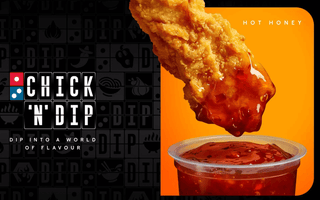 a image of a fried chicken piece being dipped into sauce.