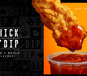 a image of a fried chicken piece being dipped into sauce.