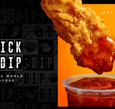 a image of a fried chicken piece being dipped into sauce.