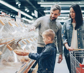 Family shopping for bread in a supermarket, illustrating how store layouts can influence customer buying behaviour.