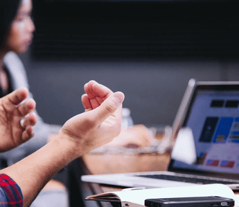 Student discussing ACCA exam schedules during a study session, with a laptop open on a desk displaying a digital calendar and exam preparation notes.