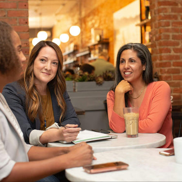 Local professionals connecting over coffee, representing ExP Community Ambassadors building awareness in their regions.