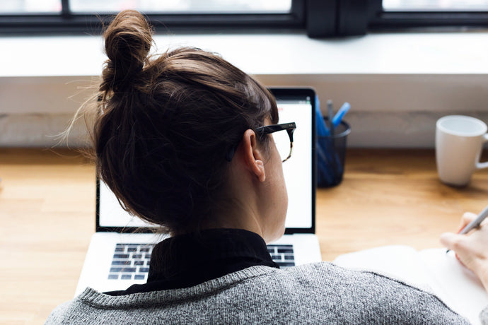 Student studying on a laptop with notebook and coffee, illustrating ExP’s highly rated online learning experience and five-star student reviews.